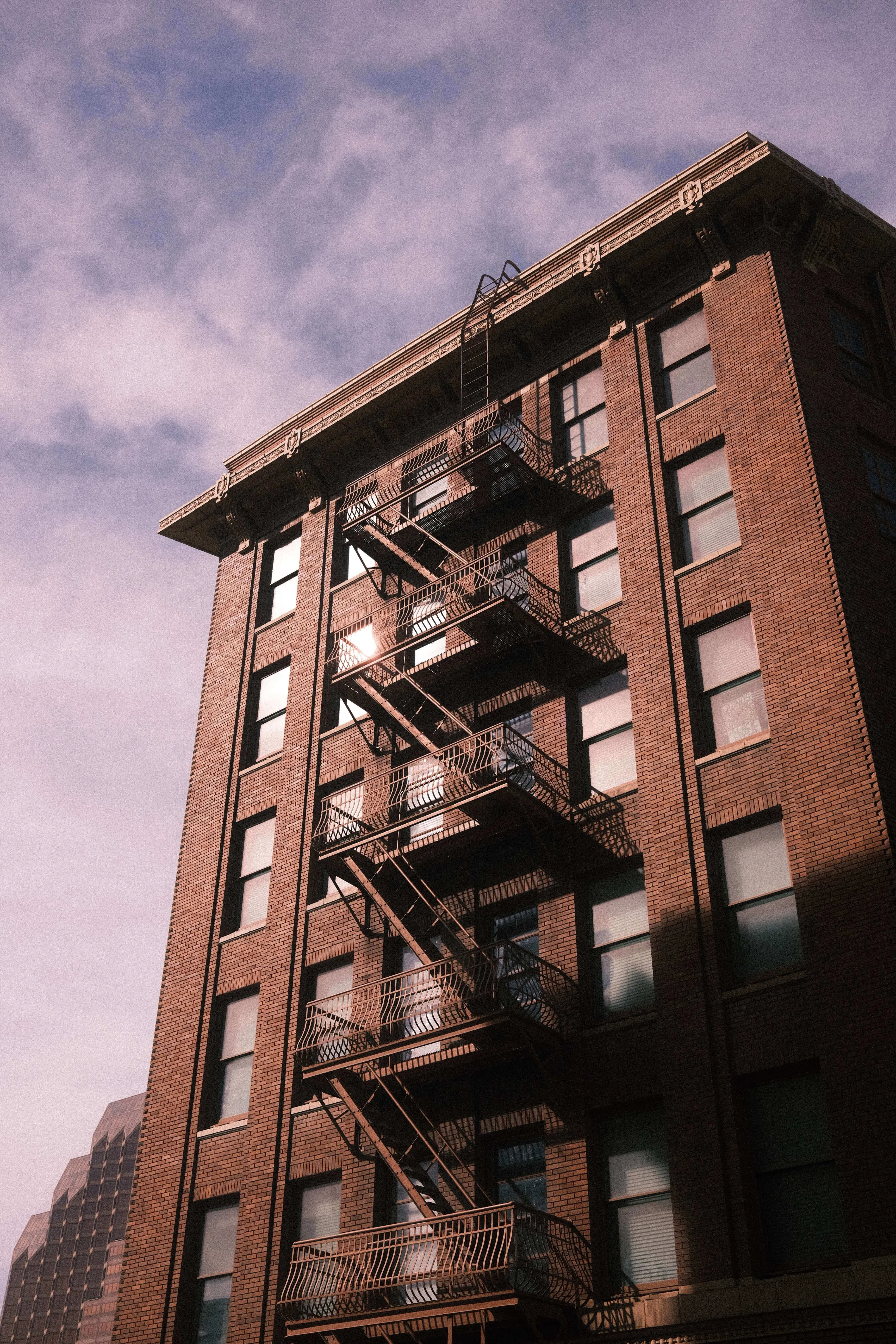 Brick building with fire escape casting shadows in downtown san antonio