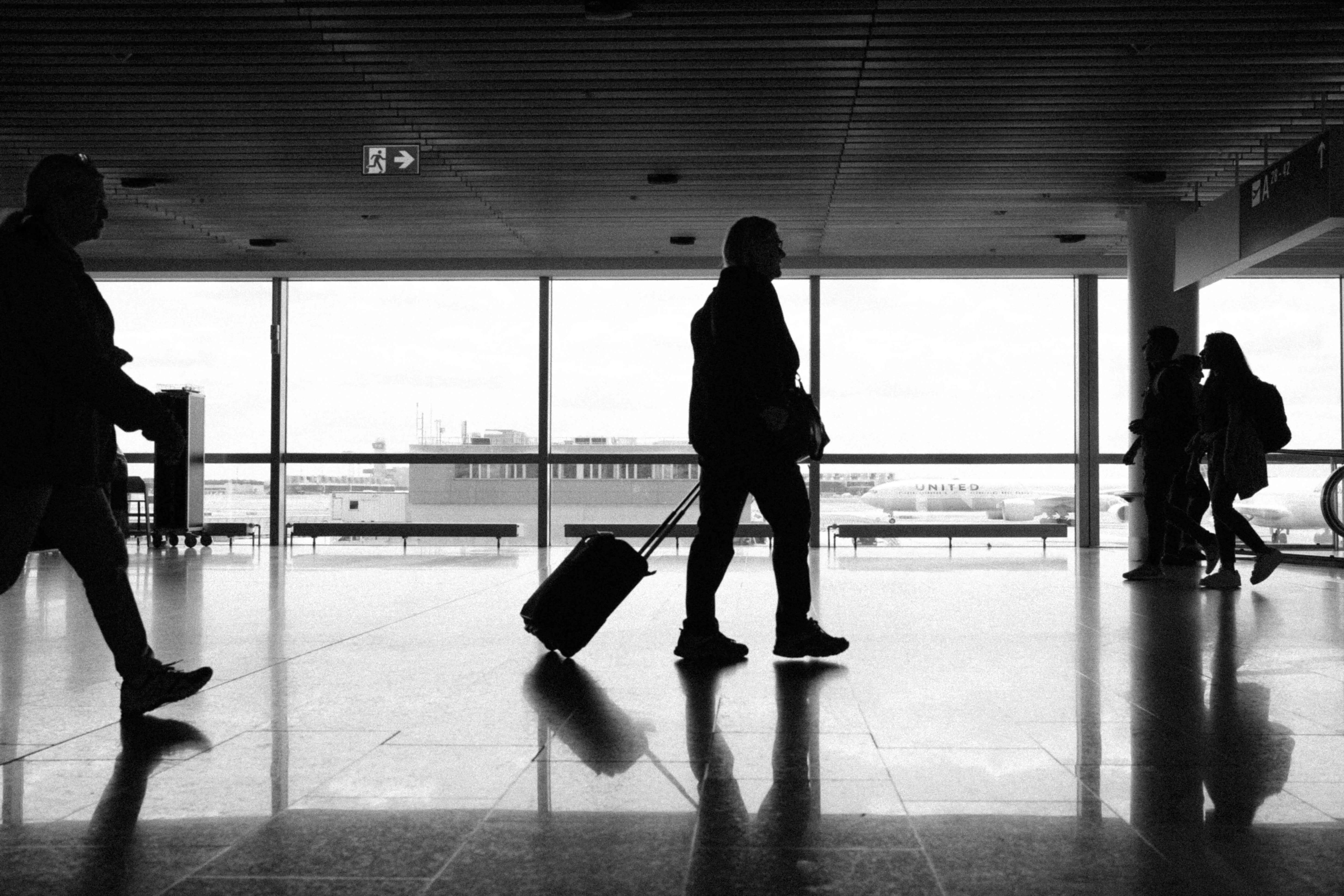 Silhouetted traveler pulling suitcase in frankfurt airport terminal
