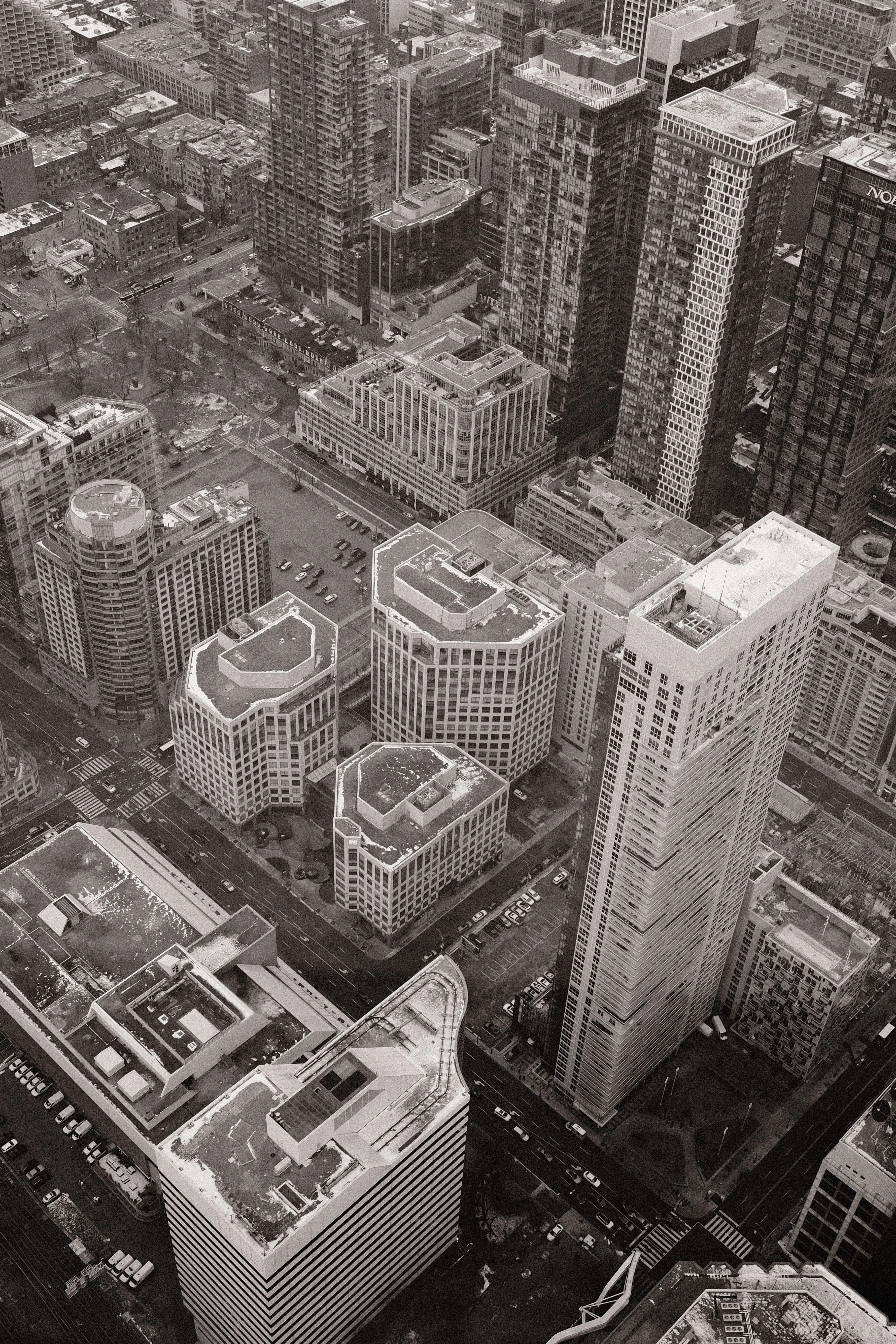 Black and white aerial view of dense urban city blocks with high rise buildings and intersections