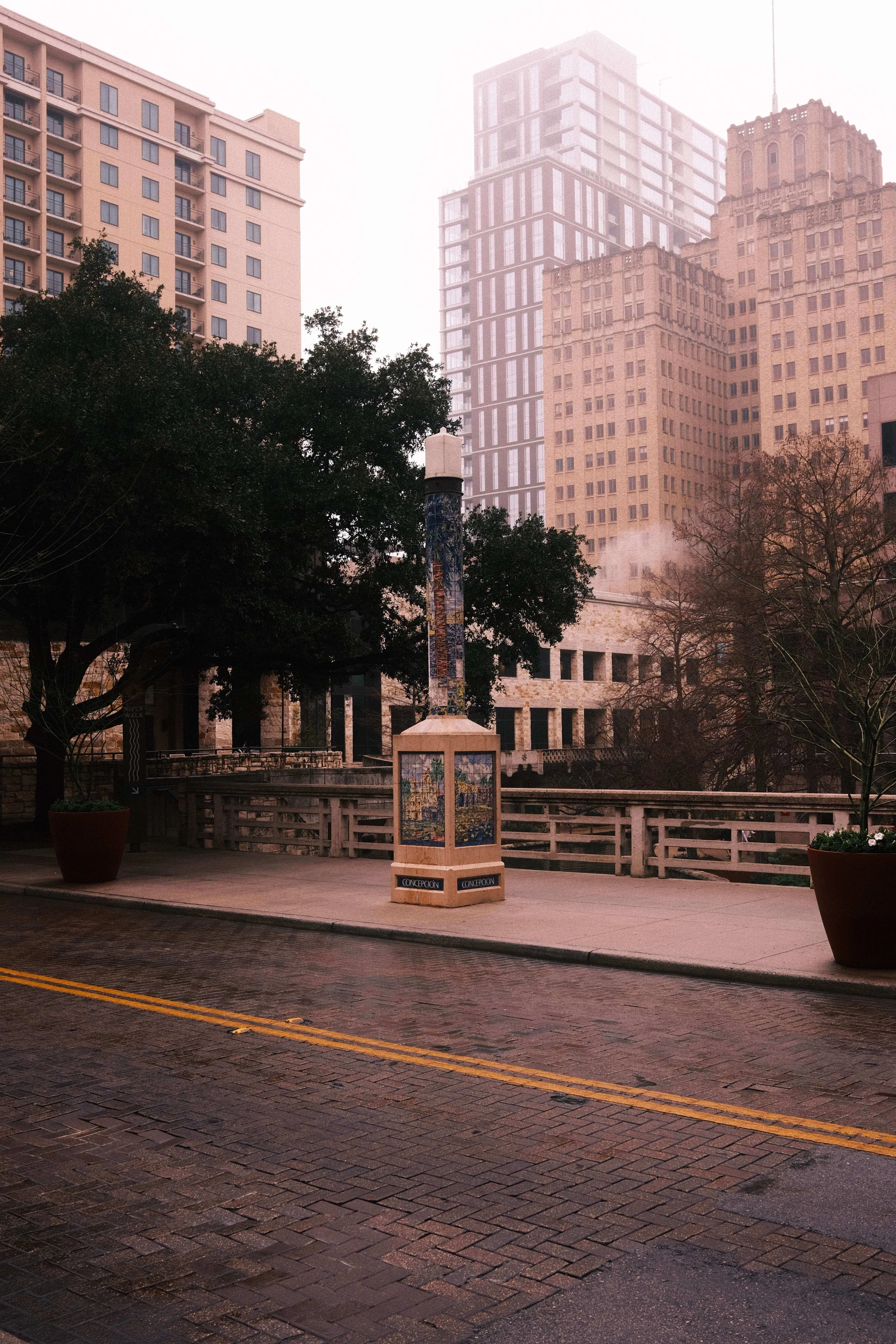 Downtown san antonio street with decorative column and surrounding buildings in soft light