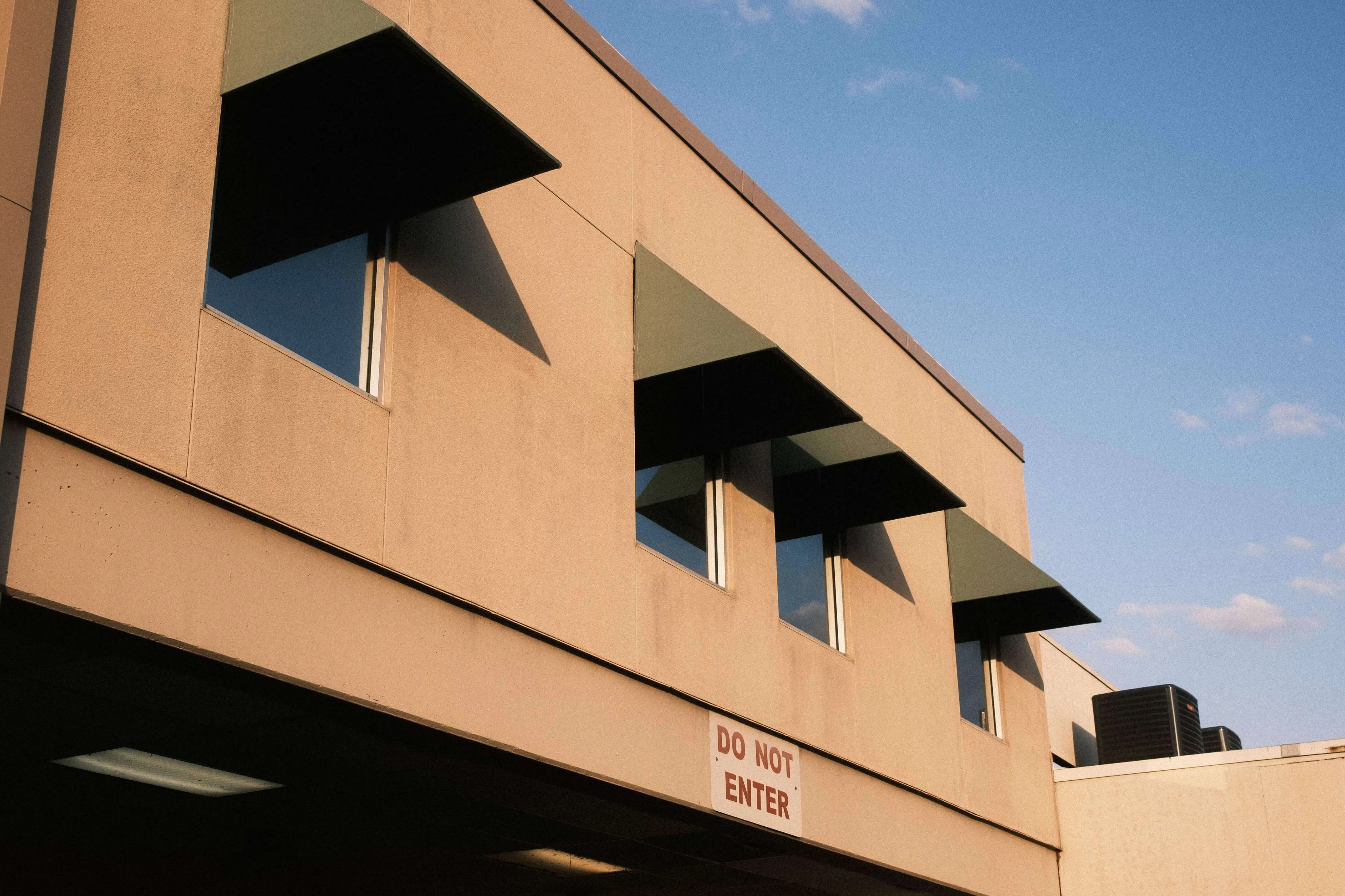Modern building windows with sharp awnings and evening light austin