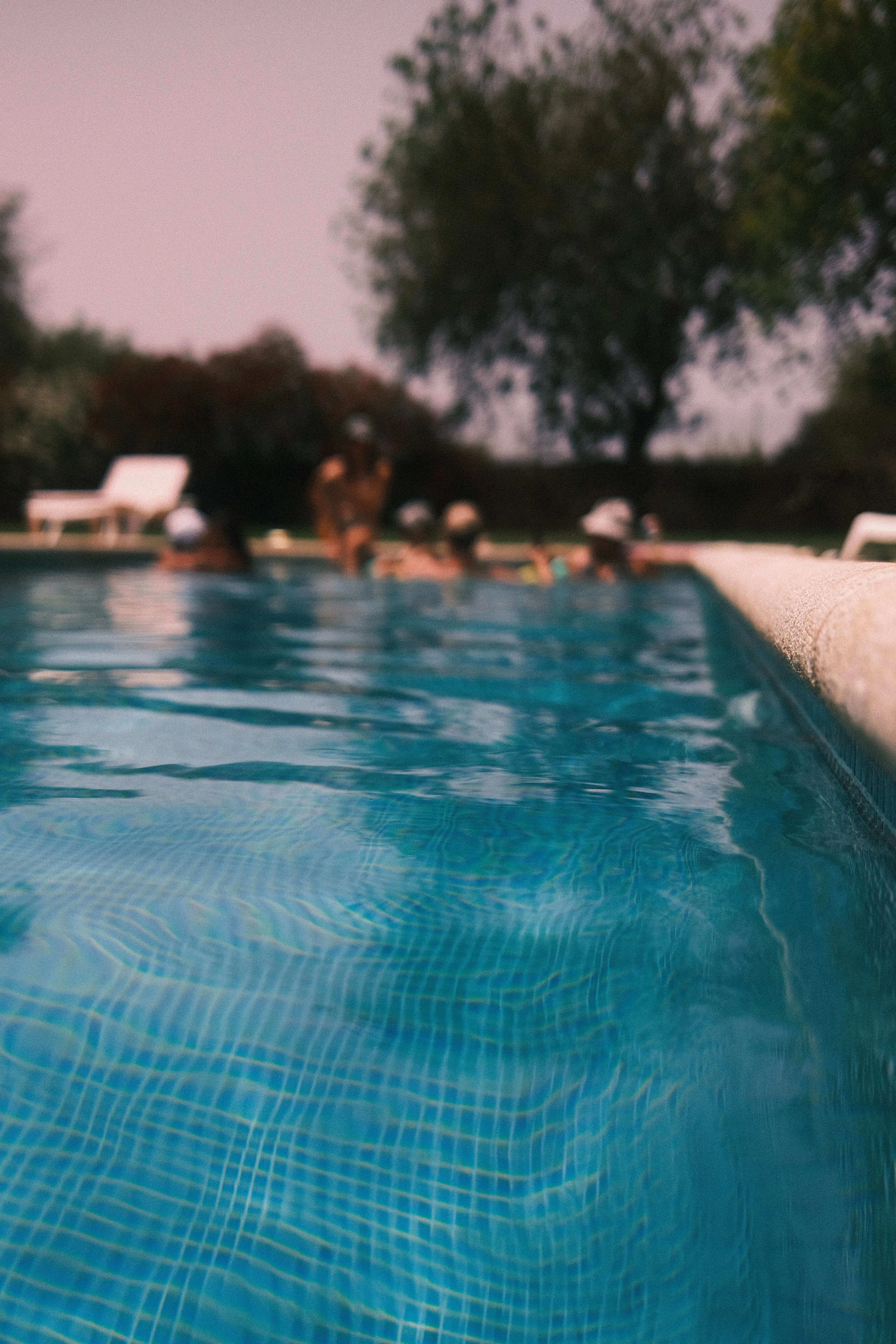 Swimming pool water with people blurred in background
