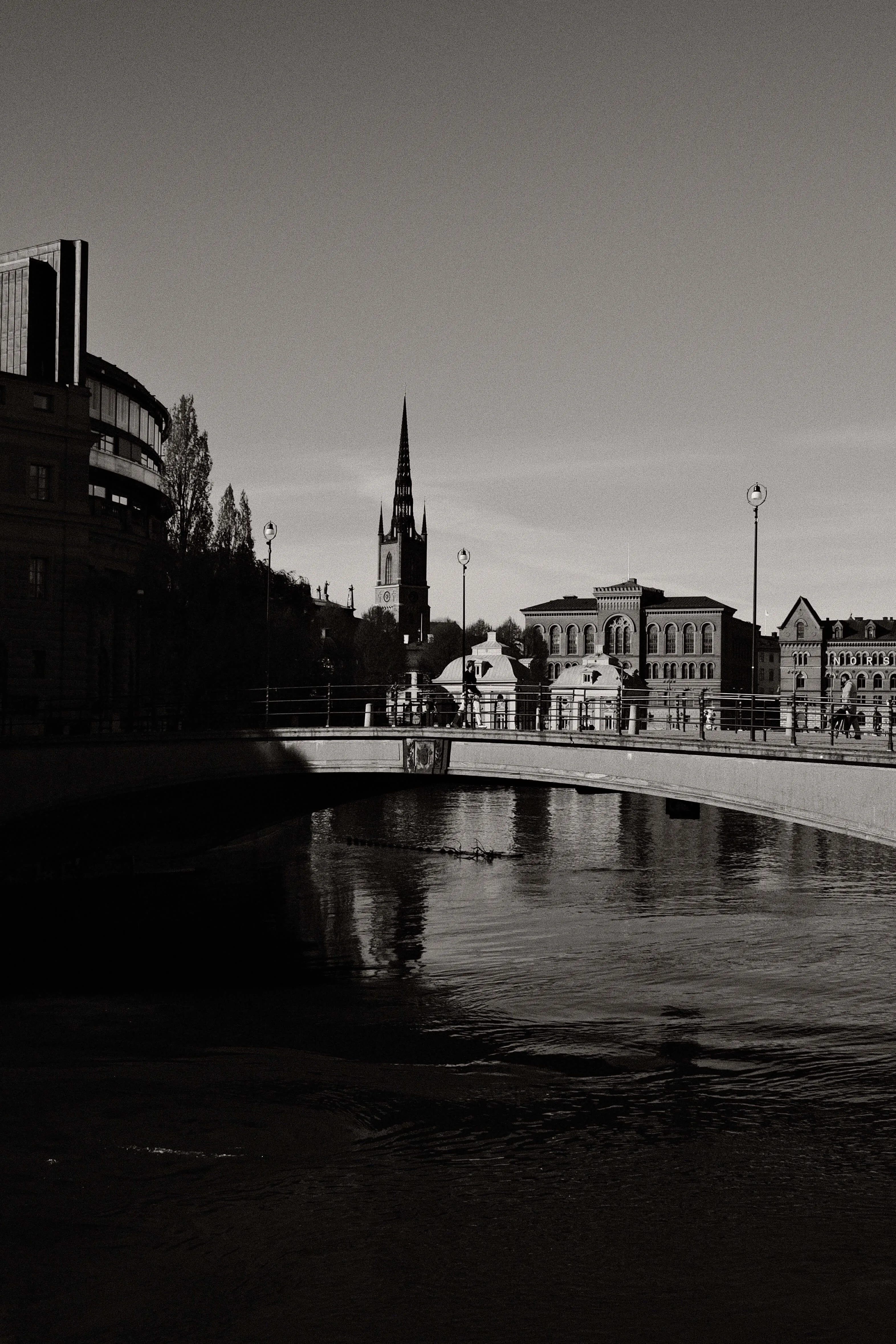 Bridge over water with city buildings in background stockholm black and white