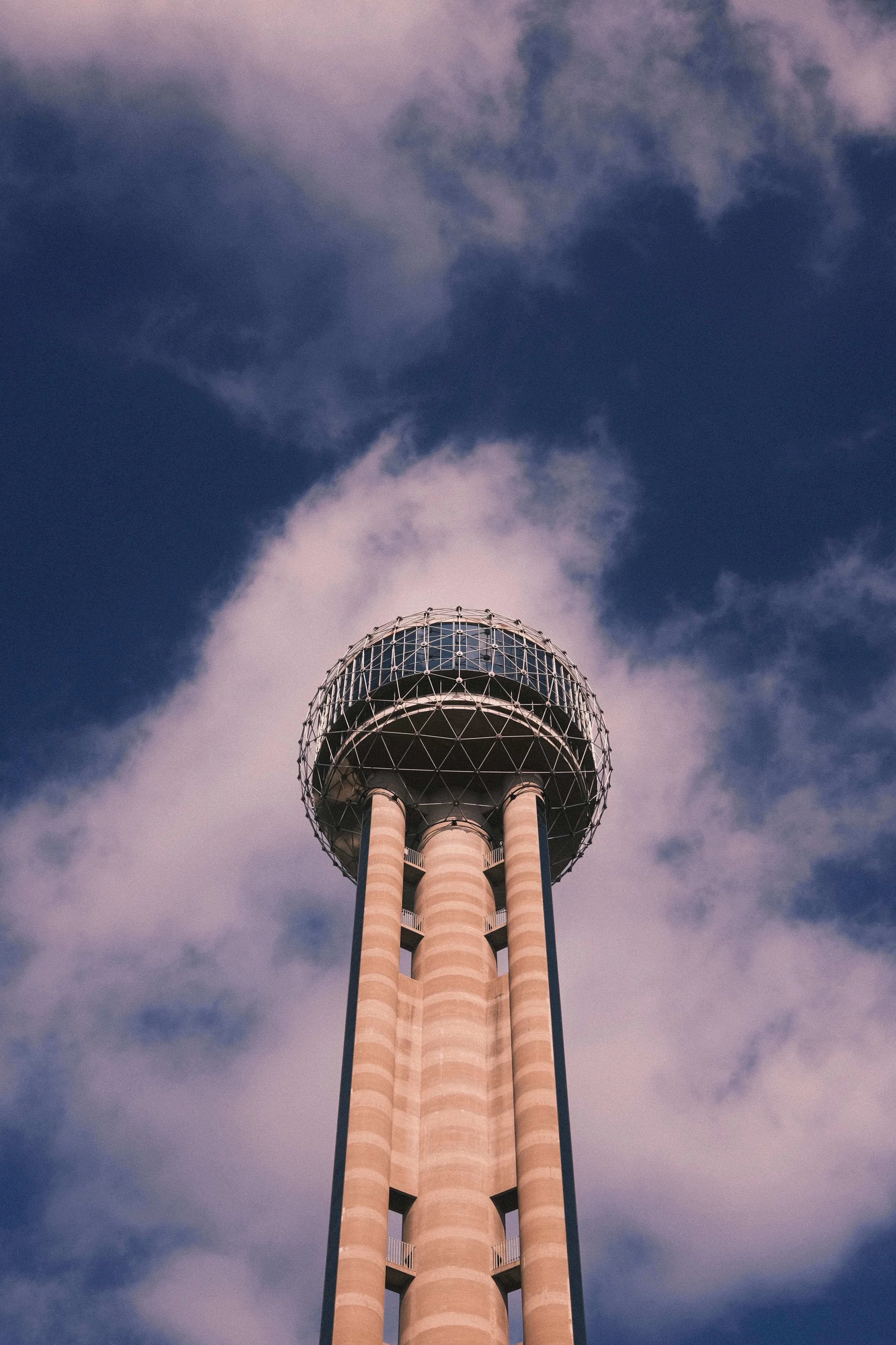 Reunion tower rising above dallas skyline against dramatic cloudy sky