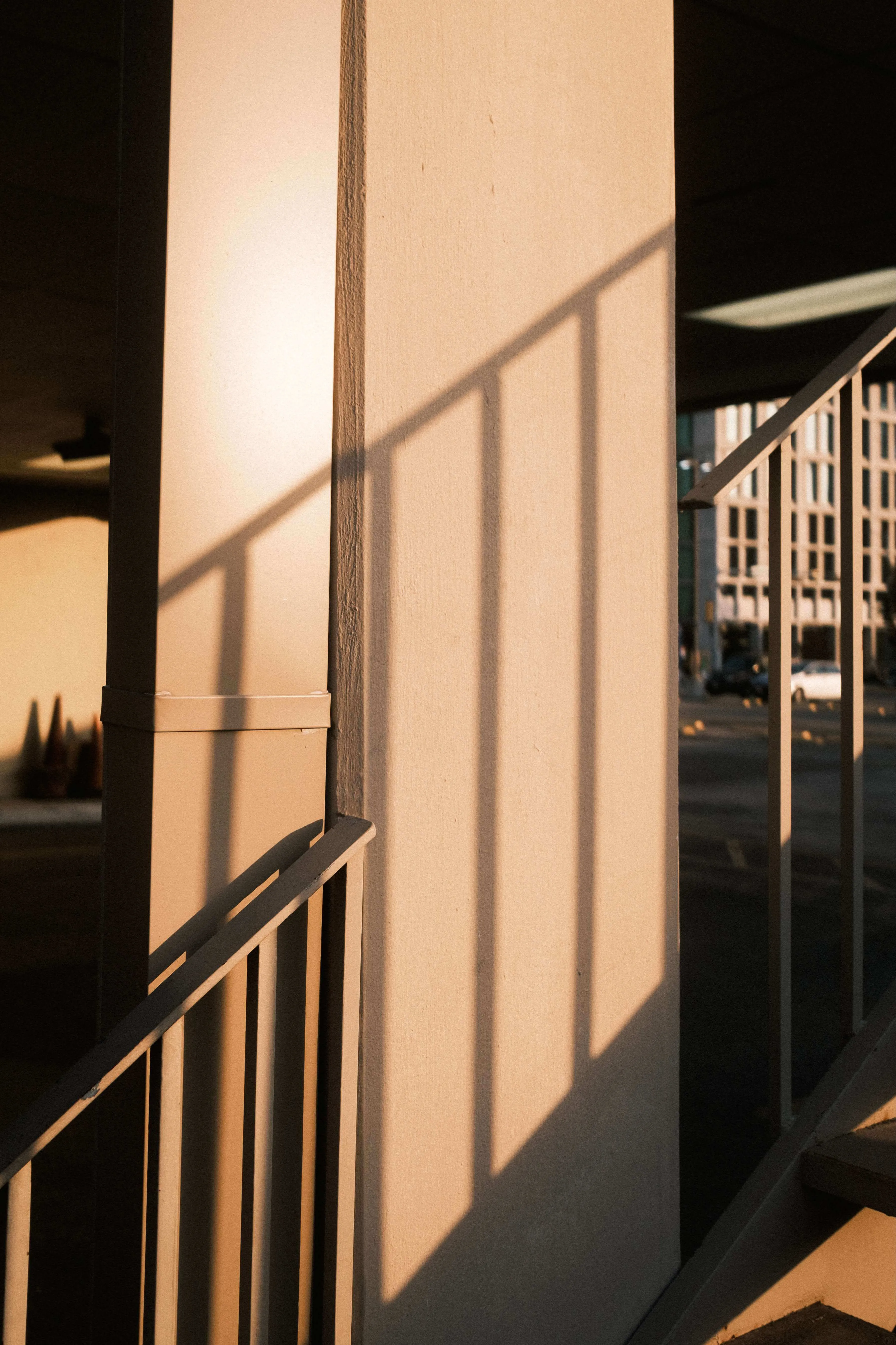 Stair railings casting long evening shadows on wall austin