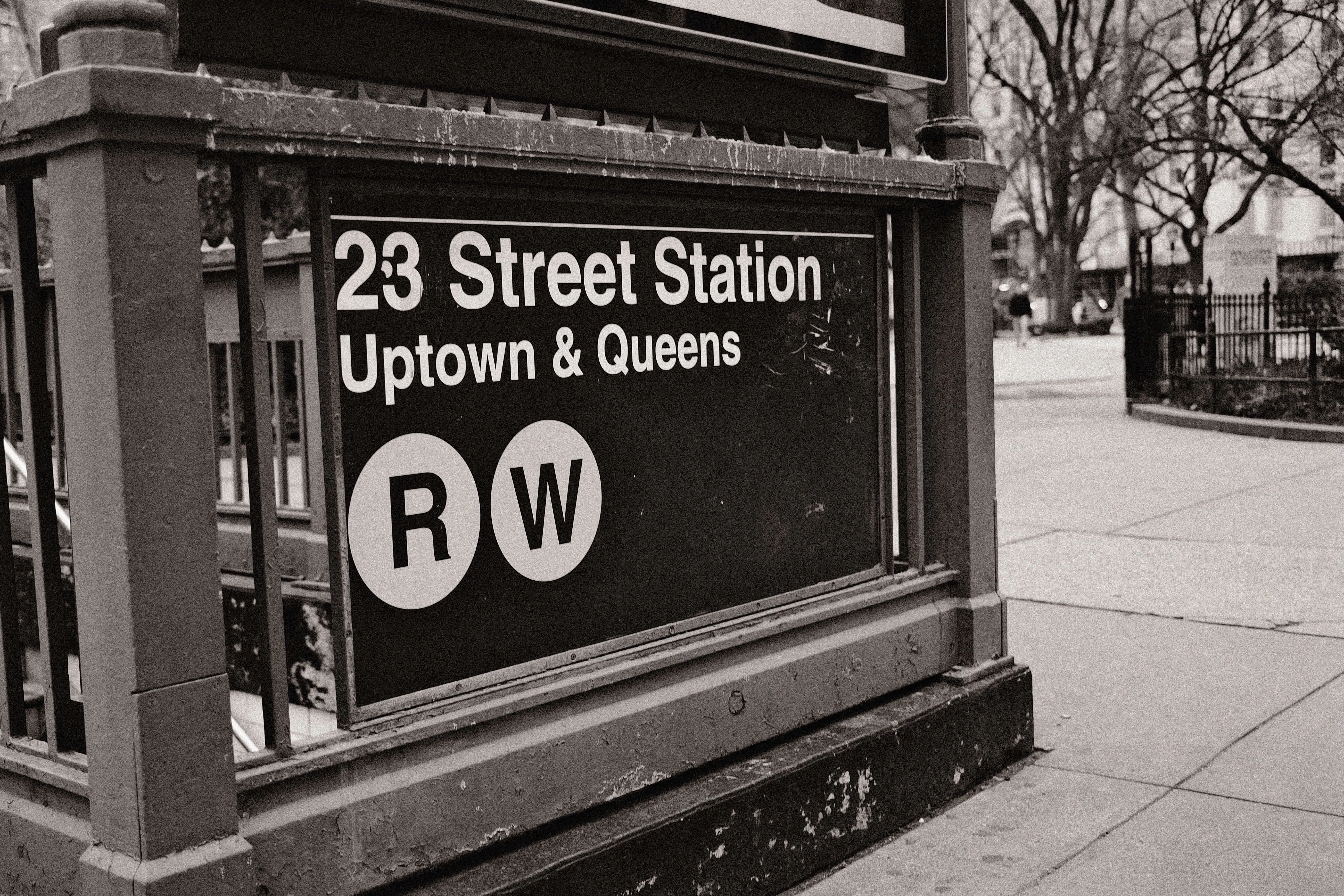 Nyc 23 street subway station sign uptown and queens black and white